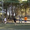 Gruppo di ragazzi gioca a calcio su un campo all'aperto.
