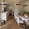 Cucina moderna con tavolo, sedie e finestra aperta.