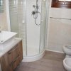 Bagno con doccia angolare, lavabo moderno e bidet.