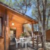 Bungalow di legno con veranda e sedie bianche.
