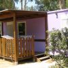 Bungalow viola con veranda e staccionata in legno.