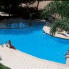 Piscina a forma irregolare con persone rilassate.