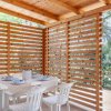Tavolo apparecchiato sotto un gazebo in legno.