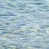 Superficie del mare con acqua trasparente e increspature.