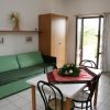 Soggiorno con divano verde e tavolo da pranzo.