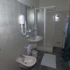 Bagno con doccia, lavandino, bidet e asciugacapelli sul muro.
