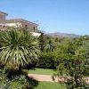 Giardino con piante tropicali e vista su case e montagne.