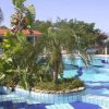 Piscina decorata con piante tropicali e mosaico a scacchi blu.