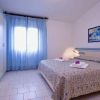 Camera con letto matrimoniale, tendaggi azzurri e quadro sul muro.