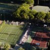 Campi da gioco e tennis circondati da alberi.