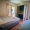 Camera con letto matrimoniale, divano e uscita sul balcone.