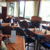 Ristorante con tavoli apparecchiati e finestre.