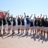 Gruppo di persone festeggia con le braccia alzate.