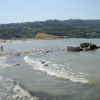 Una spiaggia con onde e persone in lontananza.