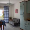 Cucina-soggiorno con tavolo, divano e vista sul mare.