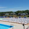 Piscina e lettini, camper sullo sfondo.
