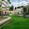 Giardino con sedute, tavoli e tende da sole.