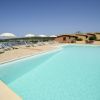 Piscina con lettini e ombrelloni, vista mare.