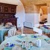Sala da pranzo con tavoli apparecchiati e mobili in legno intarsiato.