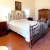 Camera da letto con letto matrimoniale in ferro battuto e mobili antichi.