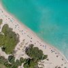 Spiaggia con ombrelloni colorati e mare turchese.