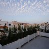 Terrazza con piante e cielo con nuvole sparse.