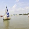 Barche a vela sul lago sotto un cielo blu con qualche nuvola.