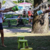 Due persone si spruzzano acqua nei pressi di un albero.