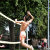Giocatori di pallavolo in azione sotto gli alberi.