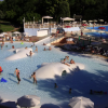 Piscina affollata con giochi acquatici bianchi.