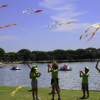 Bambini in magliette verdi giocano vicino a un lago.