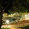 Piscina illuminata di notte, con sedie a sdraio.
