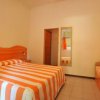 Camera con letto e divano a righe arancioni.
