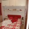 Una piccola camera con letto matrimoniale e mobili bianchi.