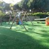 Un parco giochi all'aperto con altalene e casette.