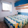 Letto matrimoniale con copriletto colorato e armadietti blu.