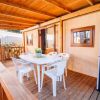 Tavolo bianco con sedie su una veranda in legno.