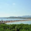 Una spiaggia con ombrelloni e colline sullo sfondo.