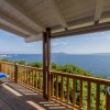Terrazza in legno con vista mare e sedie blu.