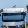 Camper bianco parcheggiato fronte mare.