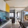 Cucina moderna con vista su una terrazza e paesaggio marino.