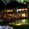 Edificio illuminato di sera vicino a una piscina circondata da sedie.