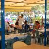 Famiglia seduta a tavoli all'aperto di un ristorante.