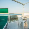 Solarium con lettino, tavolo e vista mare.