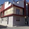 Edificio moderno a due piani con balcone in metallo e pareti rosse e bianche.