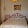 Camera da letto con letto matrimoniale, comodini e un quadro sopra la testata.