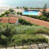 Vista su una spiaggia, piscina e tetti rossi.