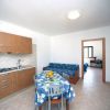 Cucina moderna con tavolo coperto da tovaglia blu a fiori, divano e stanza in secondo piano.