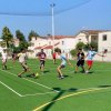 Giovani che giocano a calcio su un campo all'aperto.