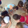Bambini seduti a terra che giocano insieme.